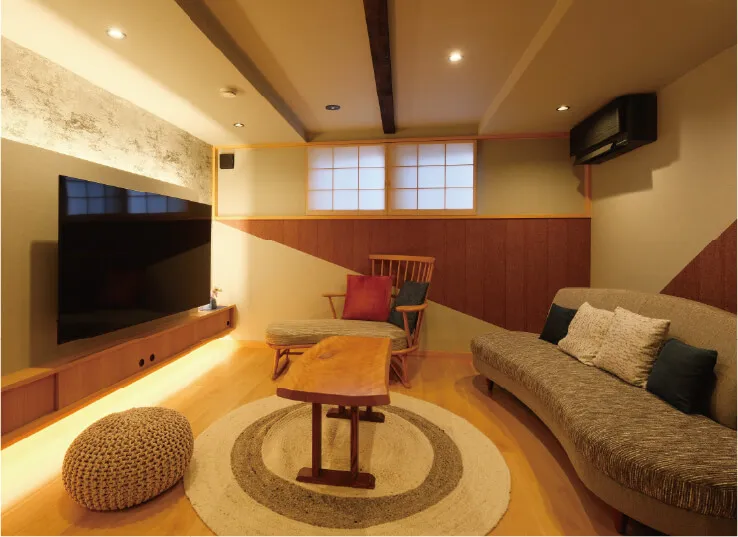 壁に取り付けられたテレビやテーブル、ソファ等があるリビングの写真