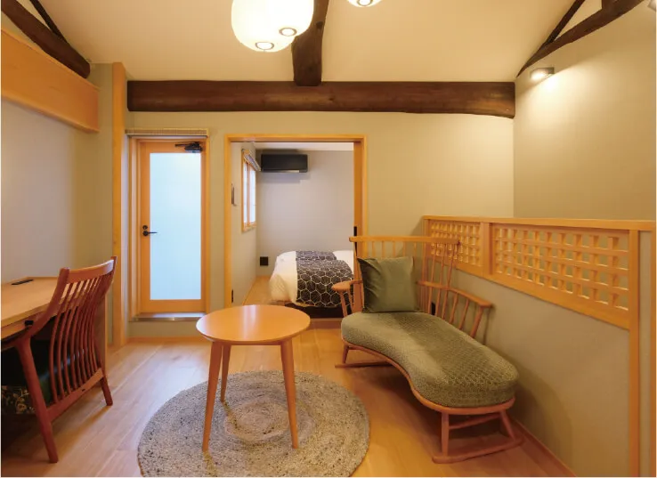 カウンターデスクとテーブルと曲線を描いたソファ等があるリビングの写真